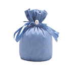 円形の青いスエードの生地のドローストリングのギフトは宝石類の包装のために袋に入れる